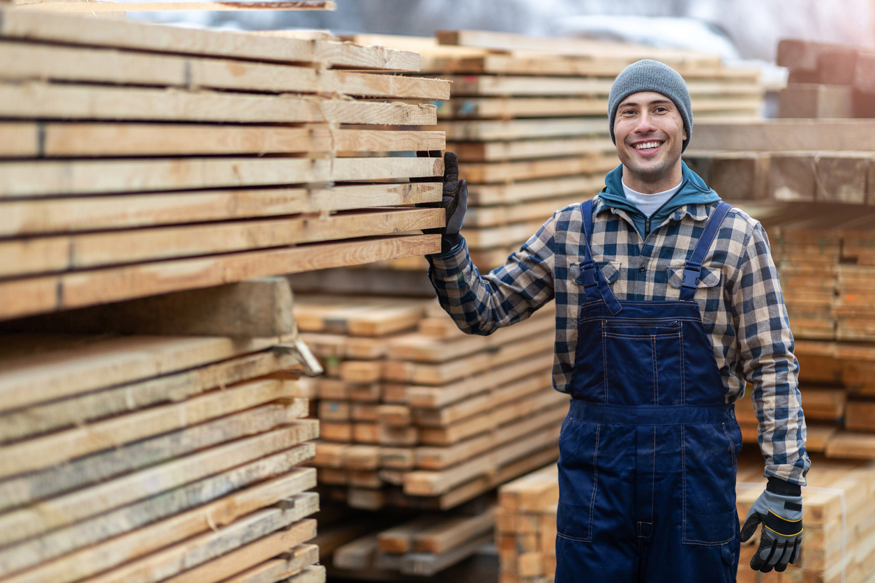 Young male worker in timber warehouse